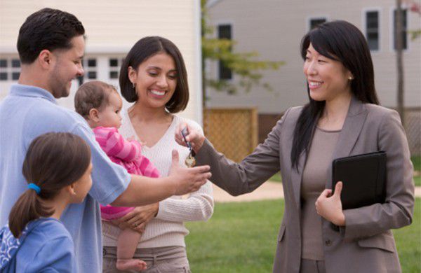 A group of people standing in front of a house.